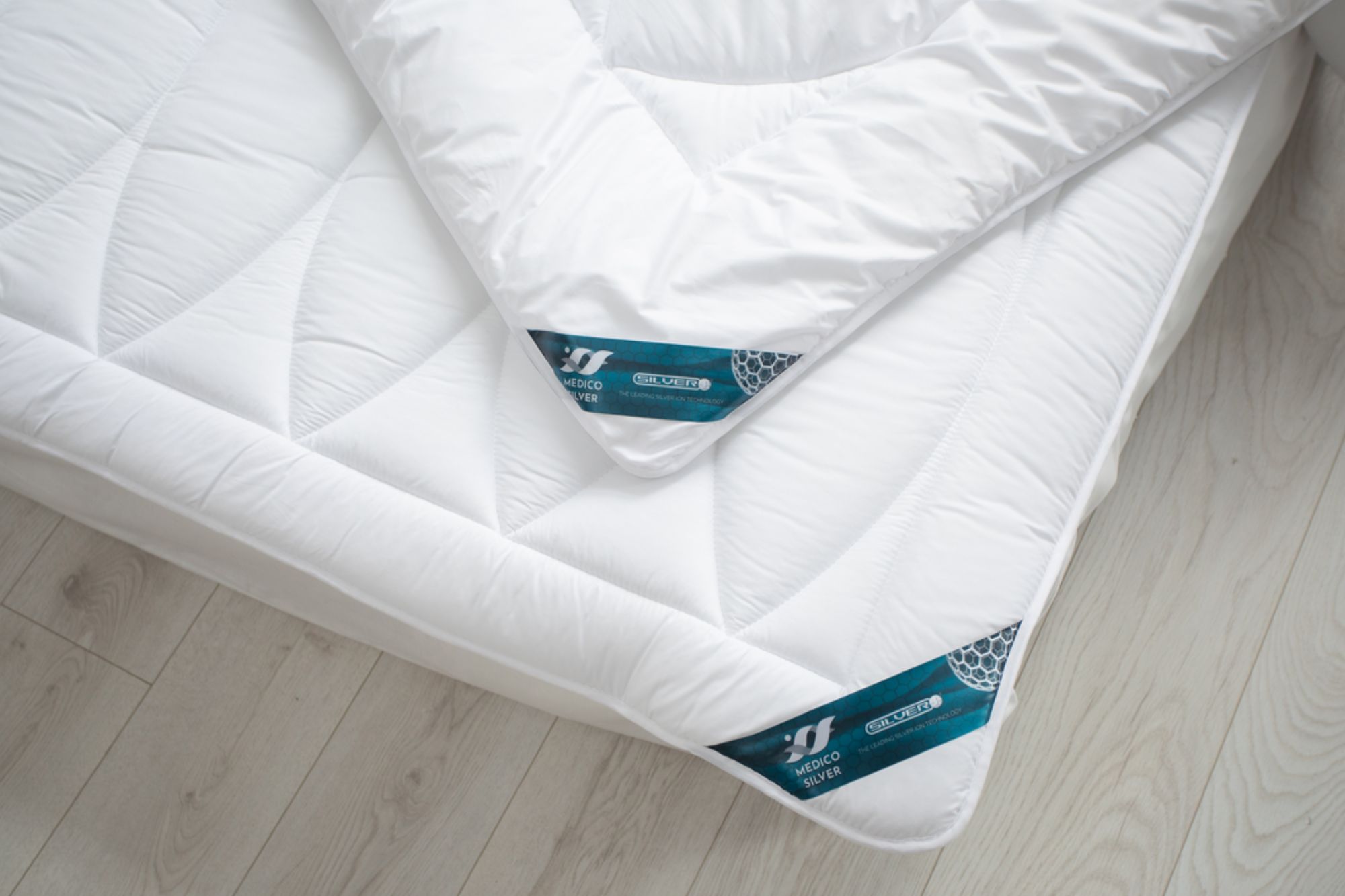 białe poduszki na łóżku z wyraźnym wzorem pikowania na jasnym tle