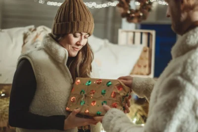 Mężczyzna wręcza kobiecie prezent świąteczny.