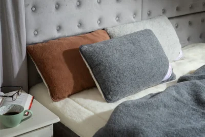 Łóżko na nim trzy poduszki wełniane merino - brązowa, szara i grafitowa