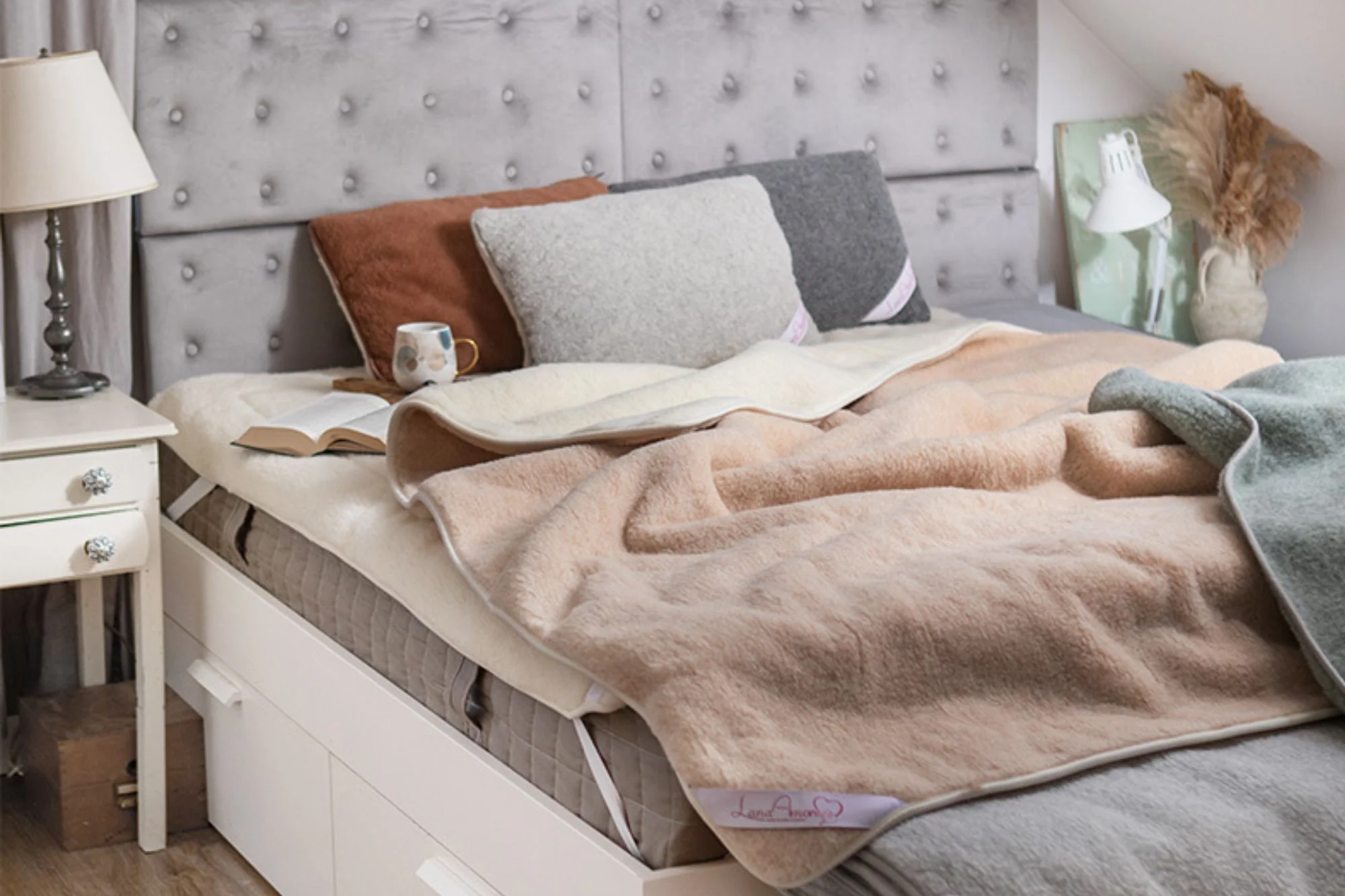 Sypialnia. Na łóżku kołdra wełniana lana amore i poduszki.