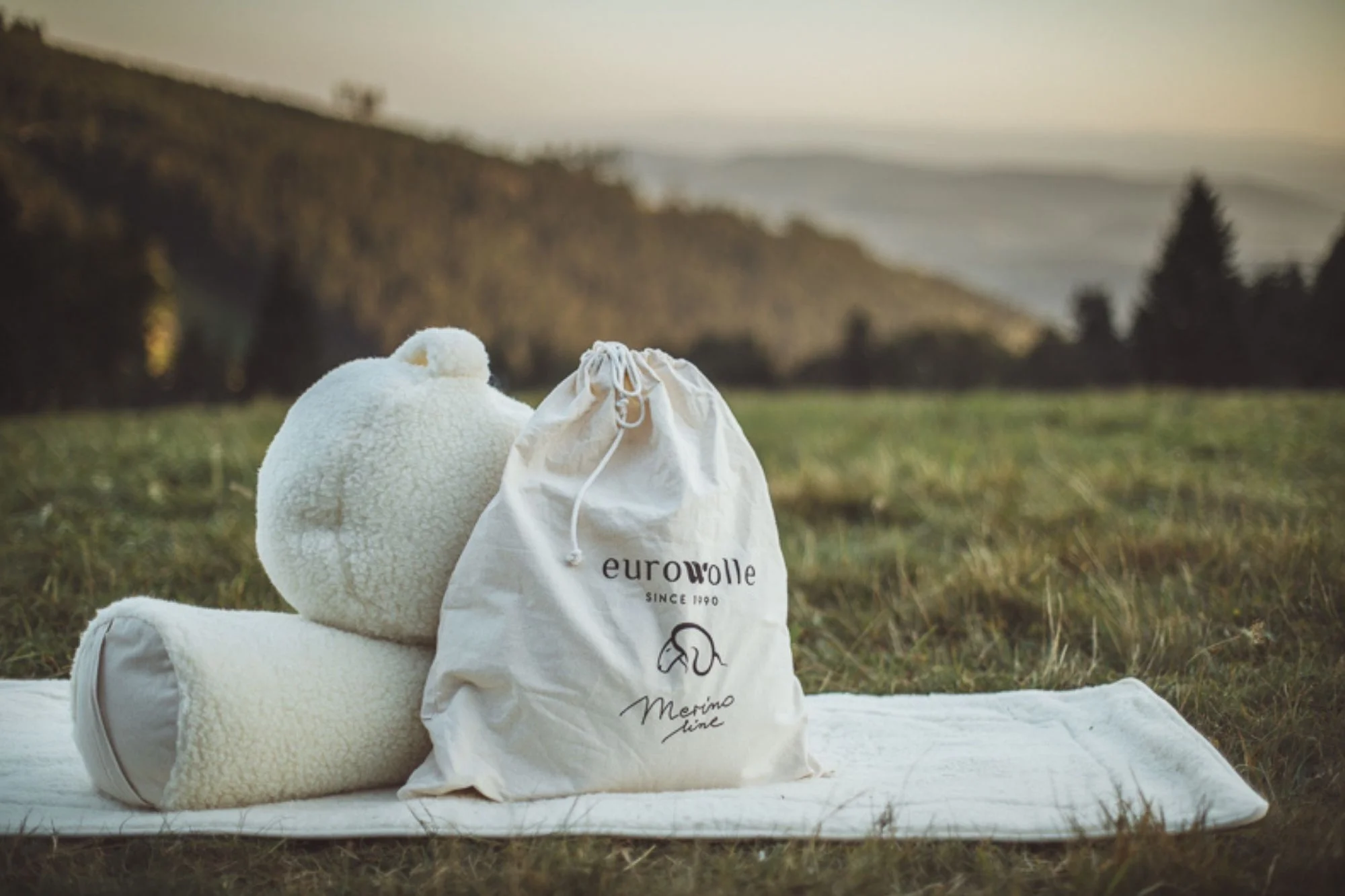 Wełniane akcesoria do jogi na tle łąki.