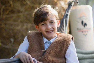 Uśmiechnięty chłopiec w kamizelce wełnianej