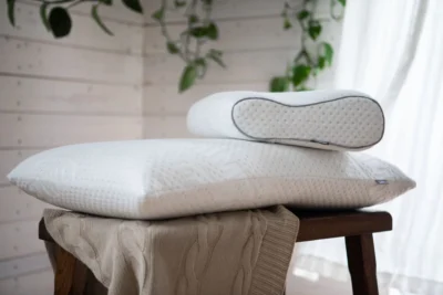 Dwie poduszki ortopedyczne leżące na drewnianym stoliczku.