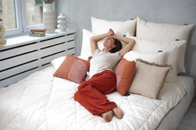 Kobieta leżąca na łóżku z ochraniaczem wełnianym