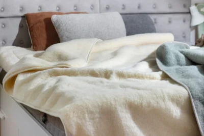 Łóżko, na nim naturalne poduszki i kołdra z wełny.