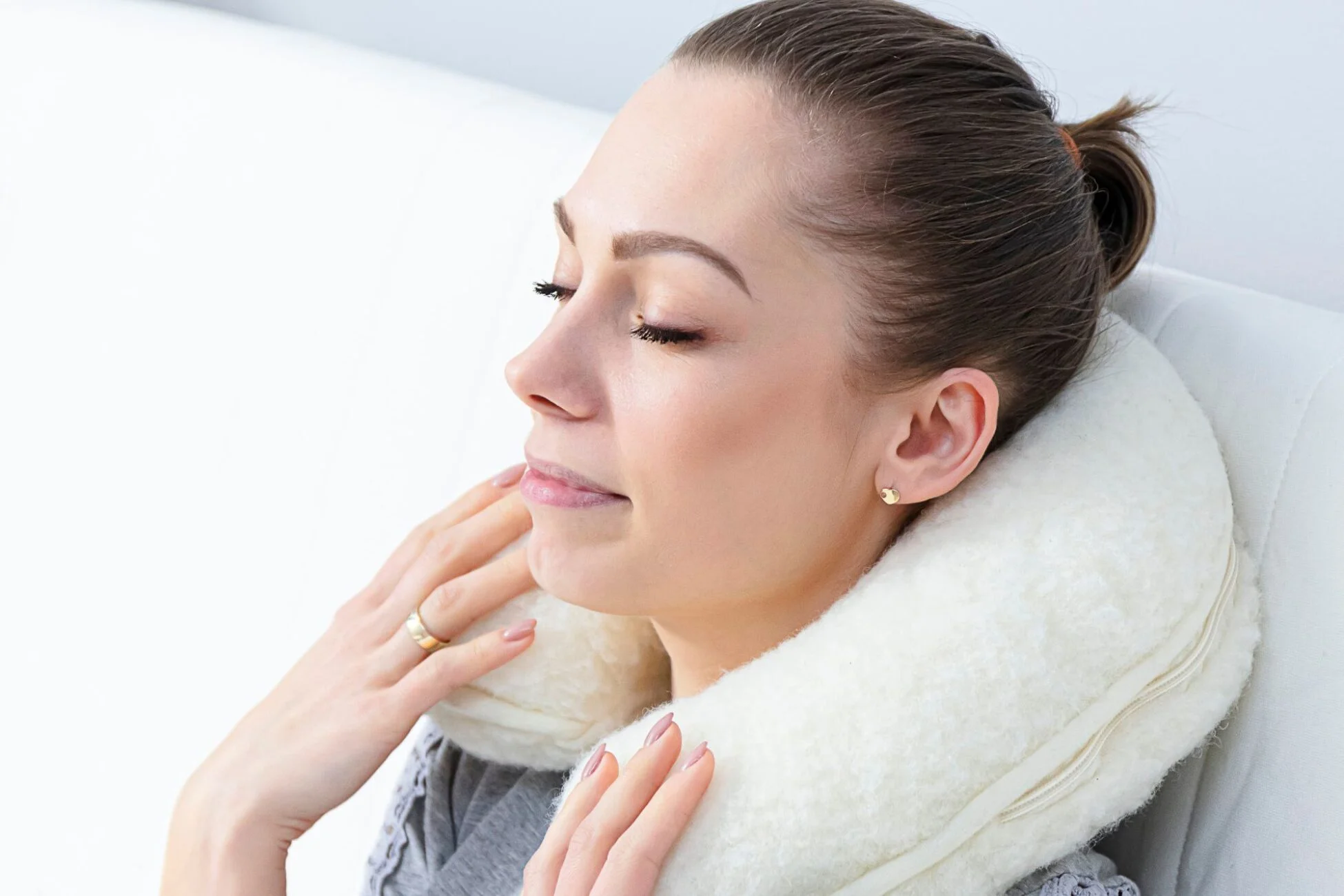 Kobieta relaksująca się z poduszką / rogalem podróżnym na szyi