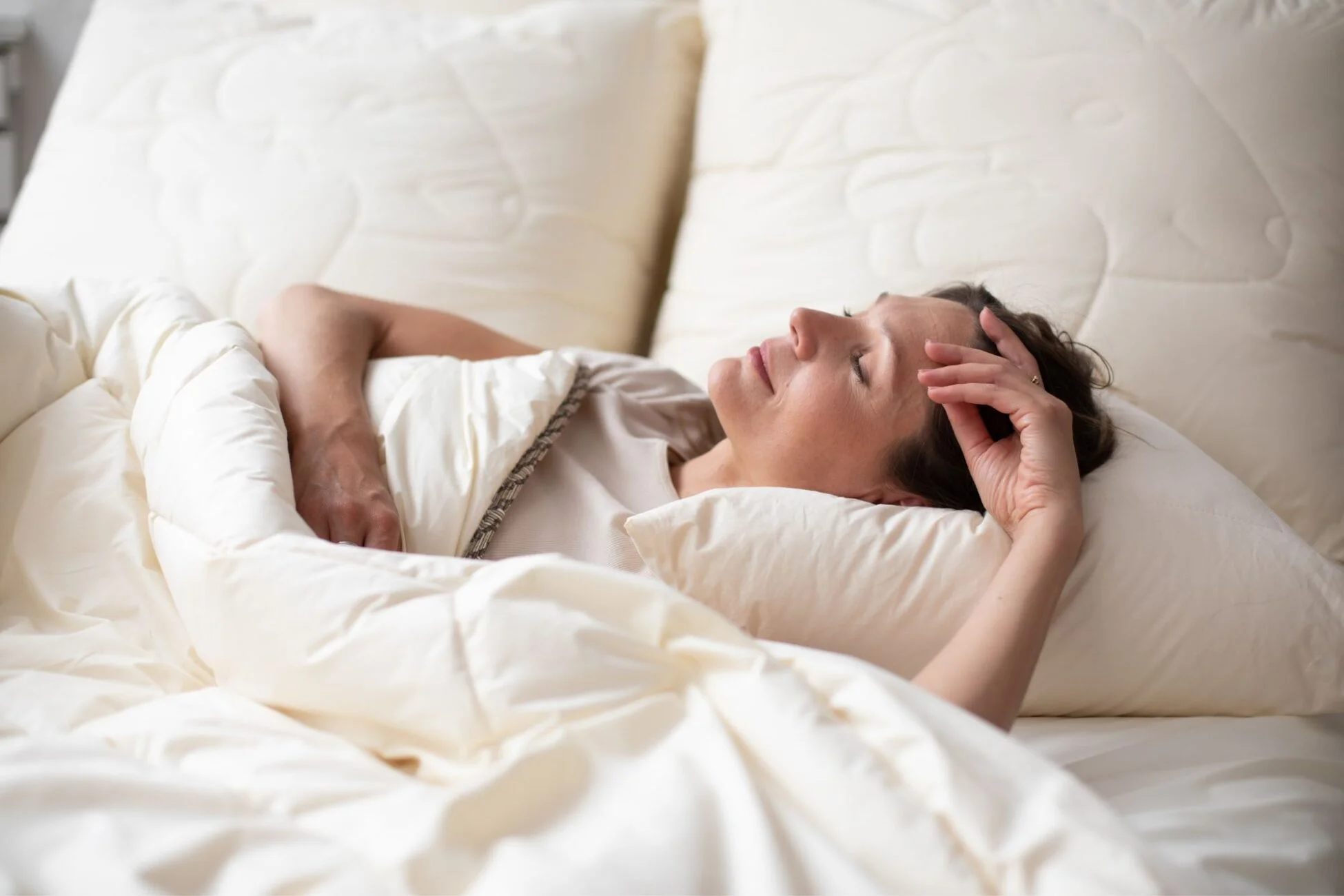 Kobieta śpiąca pod kołdrą naturalną.