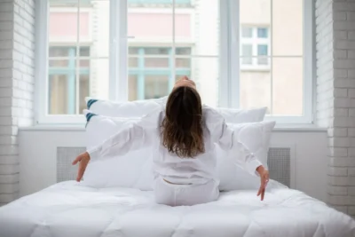 Kobieta siedząca na łóżku, pościel antyalergiczna