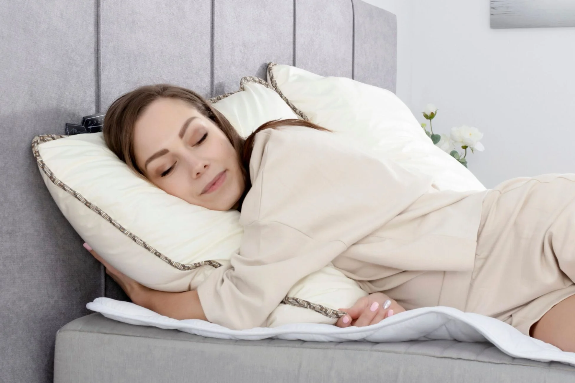 Młoda kobieta śpi wtulona w poduszkę.