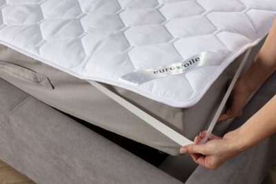 ochraniacz na materac w kolorze białym na szarym materacu