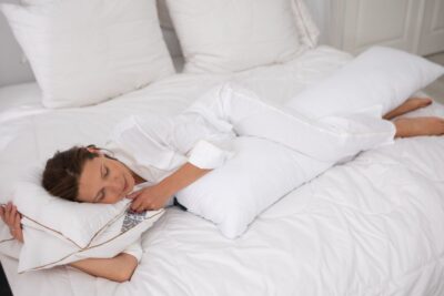 Kobieta leżąca na poduszce do spania na boku