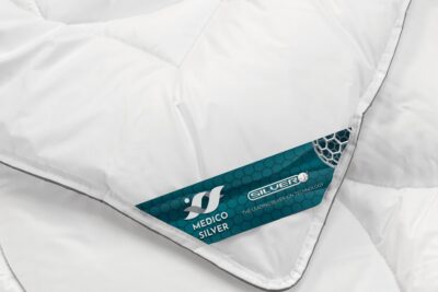 biała kołdra z etykietą na krawędzi na neutralnym tle