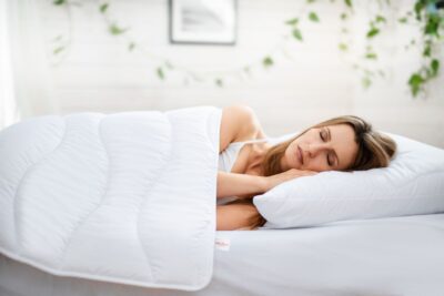 Kobieta śpiąca pod kołdrą zimową medico