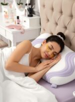 Kobieta w białej koszulce śpi na poduszce z fioletowym wzorem w sypialni z toaletką