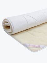 Biały ochraniacz z wełny z jasnym spodem na neutralnym tle