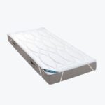 Ochraniacz na materac w białym kolorze na szarym materacu.