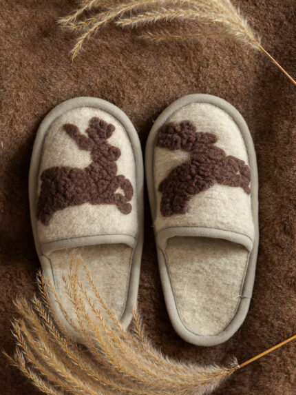 wełniane kapcie w kolorze kremowym z brązowymi jelonkami na tle brązowego materiału
