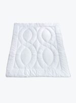 biała kołdra z pikowanym wzorem na neutralnym tle