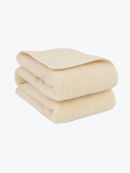 Zlożony koc ecru z wełny.