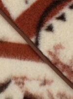 Brązowy koc wełniany z jasnym wzorem na neutralnym tle