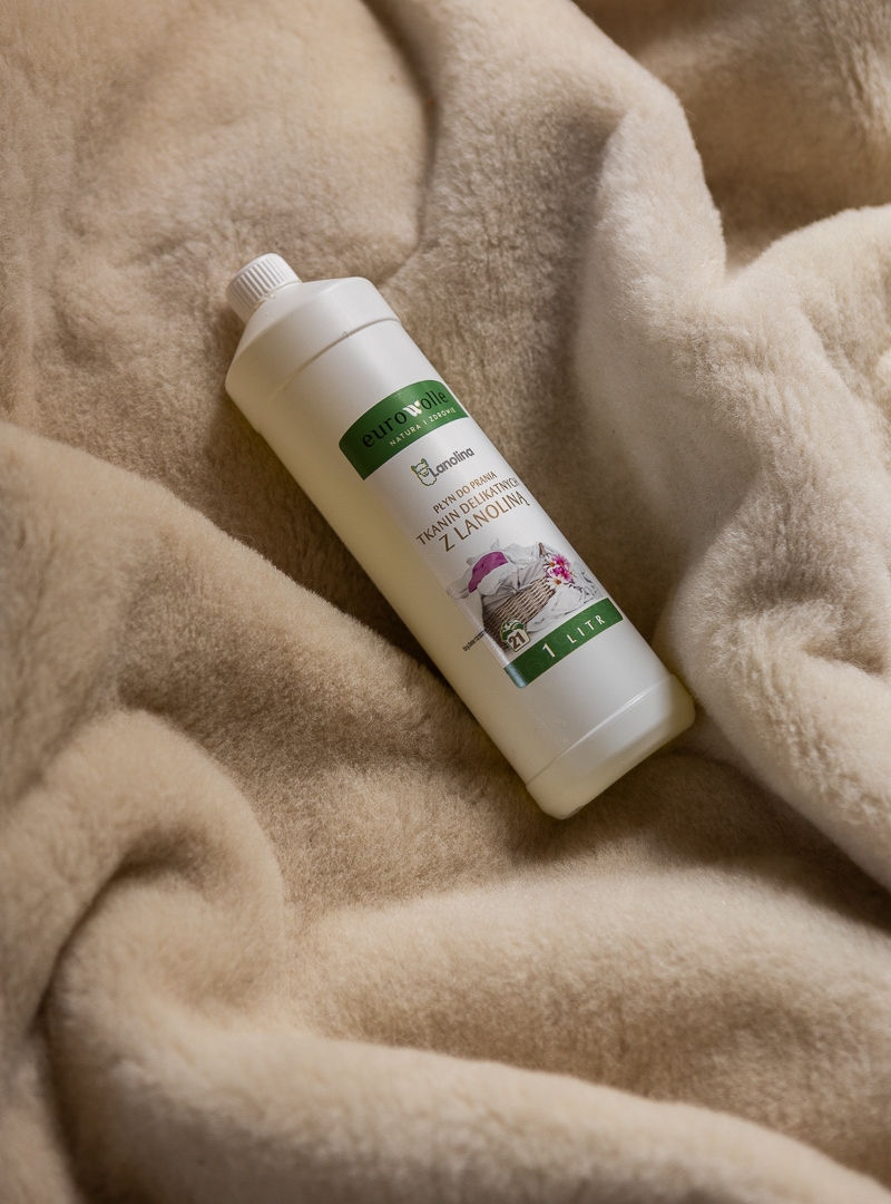 butelka płynu do prania na jasnej, miękkiej tkaninie wełnianej