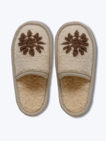 wsuwane beżowe kapcie z brązowym wzorem na górze na jasnym tle