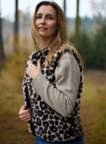 Kobieta w wełnianej kamizelce w panterkę w tle las