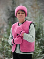 Kobieta w różowej kamizelce i opasce w lesie, w tle drzewa i śnieg.