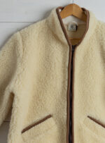 wełniana kurtka w kolorze beżowym z jasnobrązowym zamkiem i lamówką