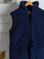 granatowy kamizelka z kapturem z kieszeniami na tle białych desek