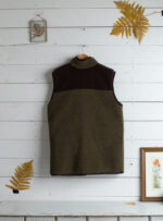 kamizelka khaki z wełny z brązowymi detalami od tyłu na tle jasnego drewna