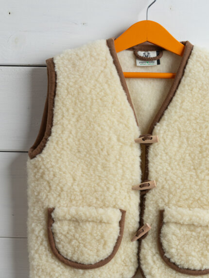 kamizelka wełniana ecru z brązowymi detalami na wieszaku