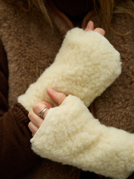 mitenki ecru z wełny na tle brązowej kamizelki wełnianej