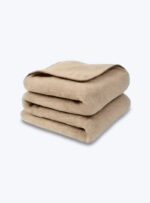 Złożony beżowa koc z wełny na neutralnym tle.