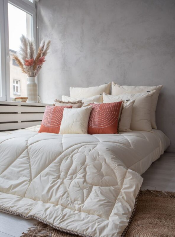 Kołdra z wełny merynos całoroczna w naturalnym kolorze na łóżku, pikowany wzór owcy