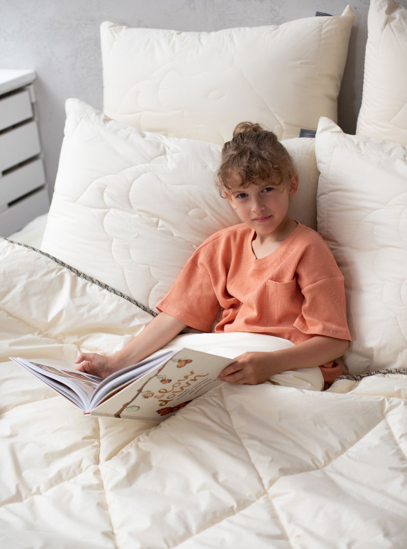 Kołdra wełniana dziecięca z wełny merino na łóżku, pikowany wzór owcy