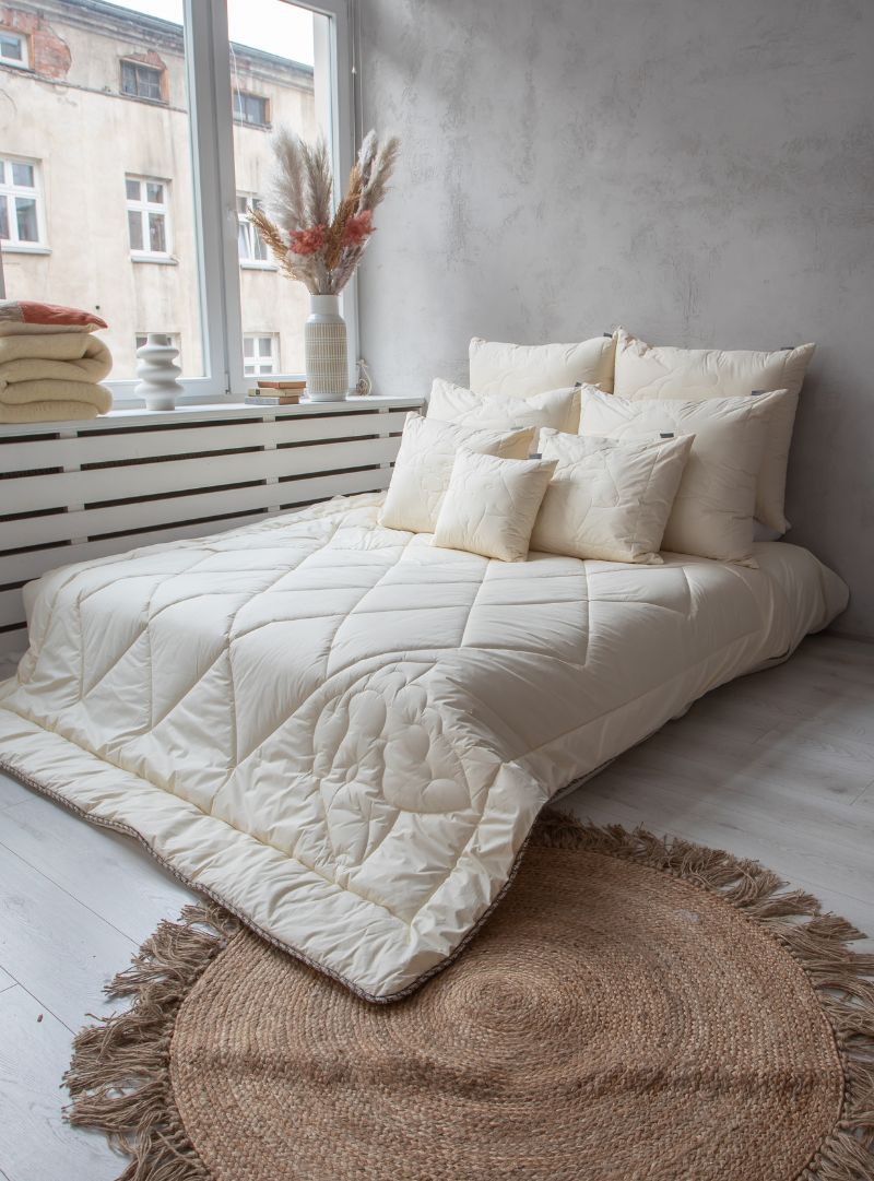 Kołdra z wełny merino letnia na łóżku, naturalna biel, pikowany wzór owcy