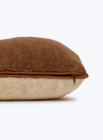 brązowo beżowa poduszka z wełny na neutralnym tle