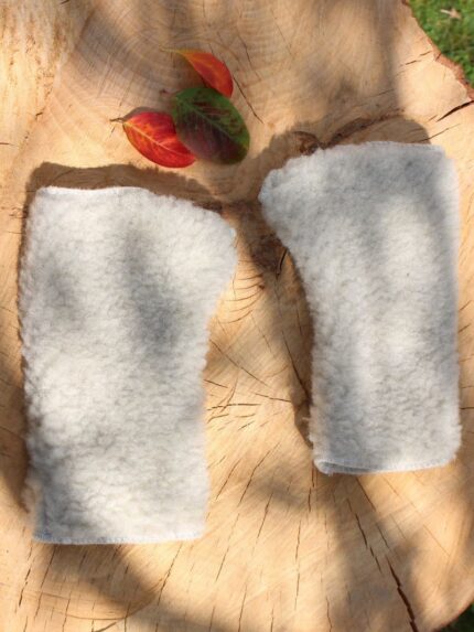 szare rękawiczki z wełny na drewnianym stole z kolorowymi liśćmi