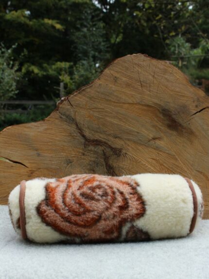 wełniana poduszka wałek w kolorze kremowym z brązowym wzorem róży