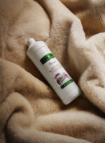 Butelka płynu do prania na beżowym tle wełnianego materiału