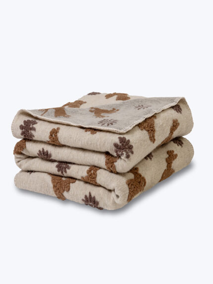 Złożony koc wełniany beżowy z brązowymi wzorami na neutralnym tle