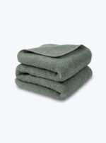 Zielony koc z miękkiej wełny na neutralnym tle