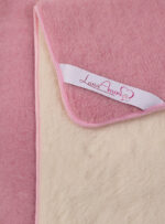 różowa kołdra z wełny z jasnym wnętrzem i etykietą na brzegach