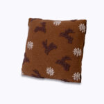 brązowa poduszka z wzorem jelonków i śnieżek na neutralnym tle