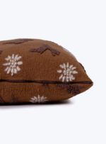 brązowa poduszka z wzorem w postaci gwiazdek na neutralnym tle