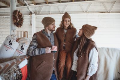Rodzina w brązowych kamizelkach wełnianych w stajni